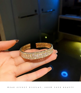 Détail d'un bracelet jonc ouvert doré orné de zircons rectangulaires étincelants