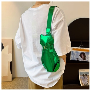 Detail of bright green metallic cat-shaped crossbody bag with wide shoulder strap