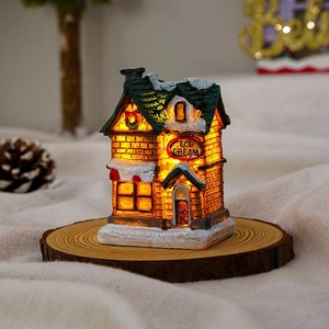 Close-up of glowing resin Christmas ice cream shop model with warm LED lights and snow