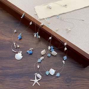 Vue détaillée des colliers bohèmes avec étoiles de mer et perles sur bois