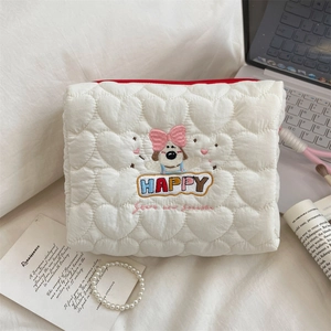 Macro detail of white quilted cosmetic bag with cute dog embroidery and red zipper