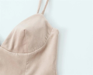 Détail d'une robe dos nu beige montrant de fines bretelles et une texture daim douce