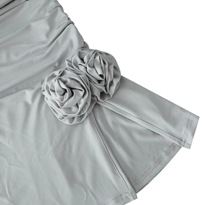 Vue détaillée de la robe grise avec fente latérale et fleurs de rose en tissu à la main