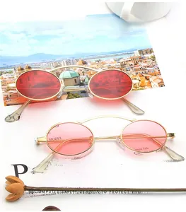 Close-up of vintage oval metal sunglasses with double arch bridge on a magazine