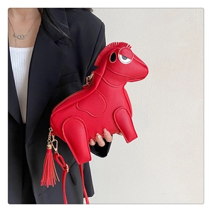 Close-up of red leather pony-shaped crossbody bag worn by a model in a black suit