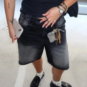Detailansicht der locker sitzenden Denim-Shorts mit schwarz-grauem Farbverlauf im Vintage-Stil