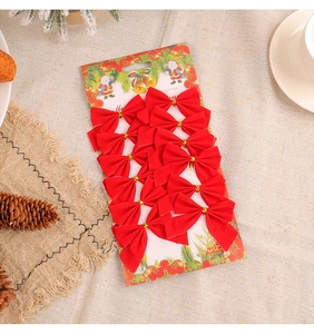 Flat lay of red flocked Christmas tree bows on packaging with pine cone and tea cup