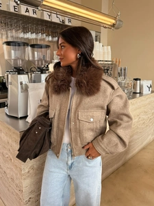 Detail of tan wool jacket with brown faux fur collar and dual front pockets