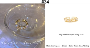 Detail of a gold adjustable ring with zircons showing water ripples and material specs