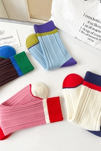 Detail of color-block ribbed mid-calf socks with vintage tricolor knit patterns