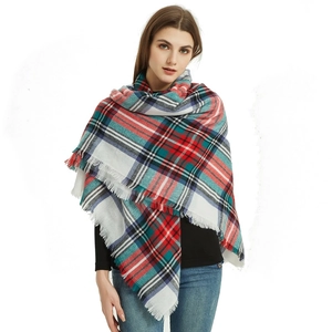 Detail shot of plaid scarf with red and green patterns and delicate fringe edges