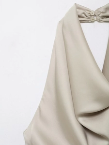 Détail du haut en satin beige avec col bénitier et fermeture boutonnée au cou licou