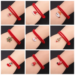 Macro detail of nine Halloween themed charms on adjustable red braided rope bracelets