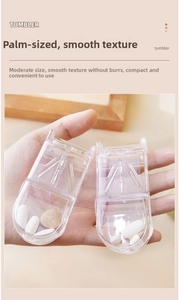 Handheld view of a compact transparent pill cutter with dual compartments and smooth edges