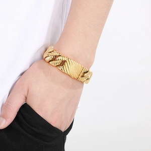 Close-up of gold chunky Cuban link bracelet with twill texture and rectangle plate on wrist