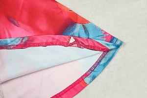 Close-up of double-needle stitching on vibrant floral print hem of mini dress