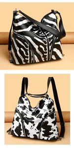 Close-up of zebra and cow print PU leather backpacks with metal zippers and black straps