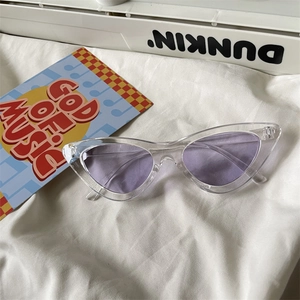 Close-up of translucent cat eye sunglasses with purple lenses and clear plastic frames