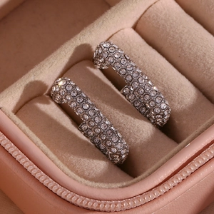 Dettaglio di orecchini a cerchio placcati oro 18K con pavé di zirconi in scatola rosa