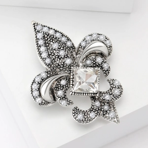 Détail de broche iris argentée avec perles élégantes et grand cristal incrusté
