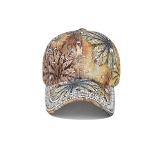 Close-up of floral baseball cap featuring hand-applied rhinestones and metallic studs
