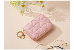 Pink quilted faux leather cosmetic bag with gold zipper and mirror shown with accessories