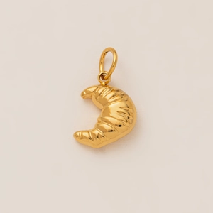 Macro shot of 18K gold plated stainless steel croissant pendant with smooth metallic texture