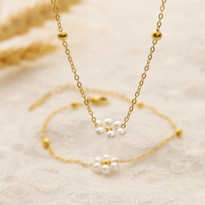 Elegant gold chain jewelry set featuring pearl flower necklace and matching bracelet