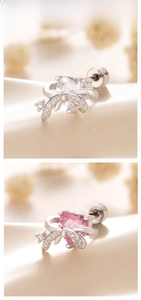 Detail of heart-shaped bow earrings in white and pink zircon with silver metal finish