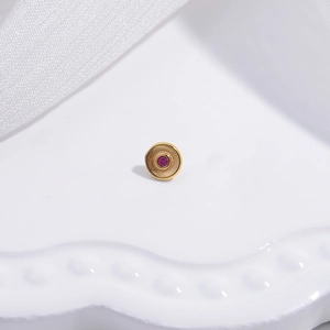 Gold stud earrings with red gemstones and matte finish on a clean white background