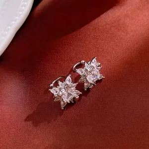 Elegant silver square zircon stud earrings with starburst design on red satin background