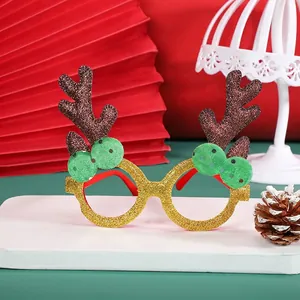 Christmas reindeer antler decorative glasses with gold glitter and green pom poms on wood