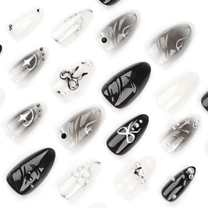 Faux ongles amande à motif marbré noir avec nœuds métalliques 3D et étoiles argentées