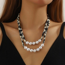Close-up of double-layer necklace with leopard print fabric and large white pearls