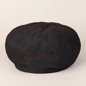 Close-up of black denim baker boy hat with decorative red contrast stitching detail