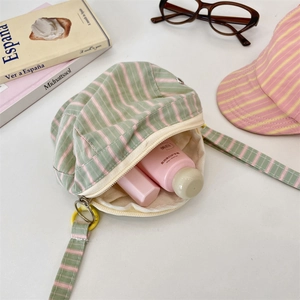 Detail of striped canvas crossbody bag showing inner storage space for small cosmetics