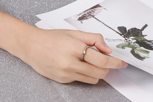 Gros plan d'une bague en argent en forme de V sertie de diamants sur la main d'un modèle