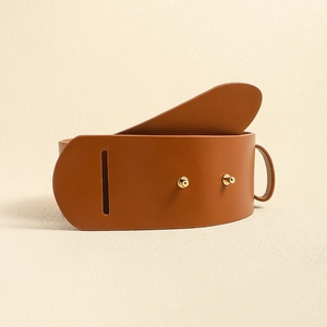 Detailed view of a wide brown leather belt with elegant gold metal buckle on beige surface