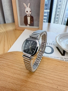 Macro detail of rectangle black dial and silver metal strap on minimalist ladies watch