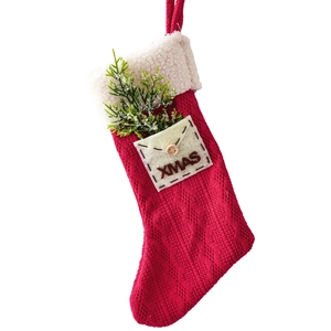 Red knit Christmas stocking with white fleece cuff and XMAS envelope pocket design