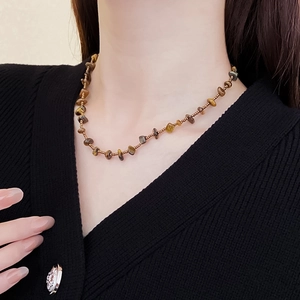 Detail of tiger eye stone necklace with irregular beads on a female model
