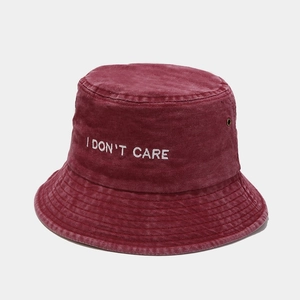 Detail of burgundy washed cotton bucket hat with white I DON'T CARE embroidery and eyelet