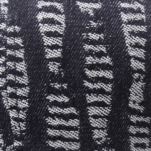 Macro detail of dark blue jacquard denim fabric with white textured abstract patterns