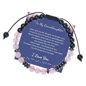 Dettaglio del bracciale codice Morse con cristallo rosa e pietra opaca e biglietto d'auguri