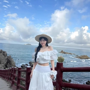 White off-shoulder crop top and embroidered long skirt two-piece vacation set on seaside