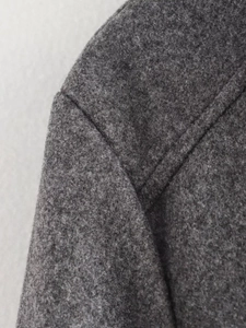 Close-up of shoulder seam and melange gray wool-like fabric texture on casual jacket