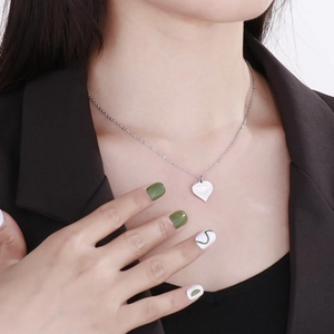 Close-up of heart-shaped stainless steel pendant necklace on a person neck