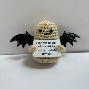 Handmade knitted potato doll with black wings holding a humorous English quote card