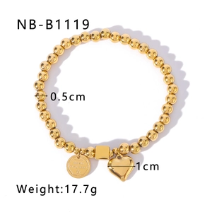 Detailed macro view of gold beaded chain bracelet with engraved sky and crown charms