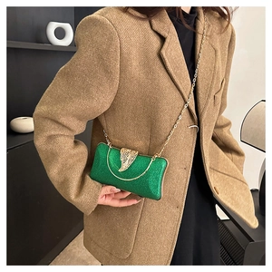 Detail of green sequin evening clutch with gold chain strap and metallic leaf lock